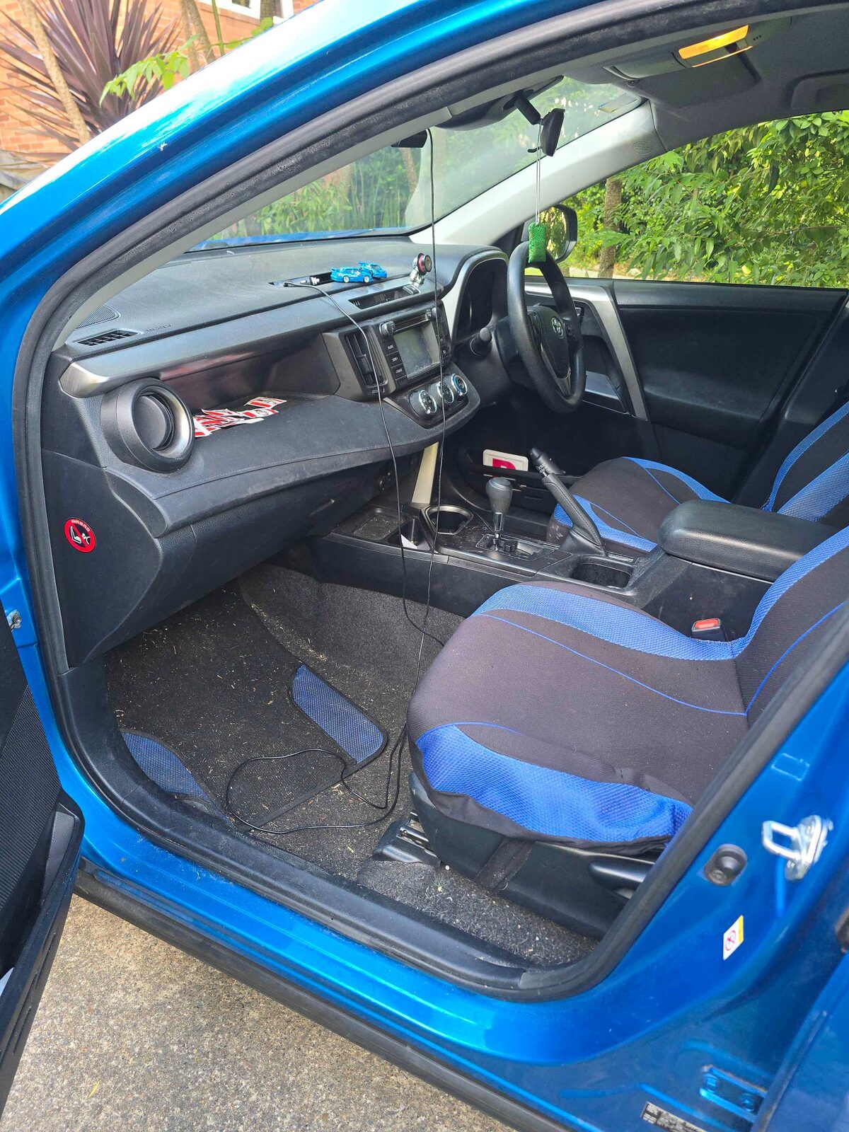 Car interior before cleaning — dirty floor mats and cluttered cabin